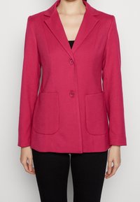 Blazer fucsia con colletto a punte, due tasche frontali e chiusura a due bottoni; presenta una vestibilità sartoriale e un tessuto testurizzato.