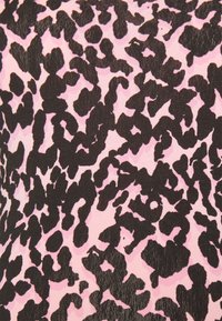 Design de estampado de leopardo negro sobre um fundo rosa claro, apresentando formas irregulares e uma superfície de tecido texturizada.