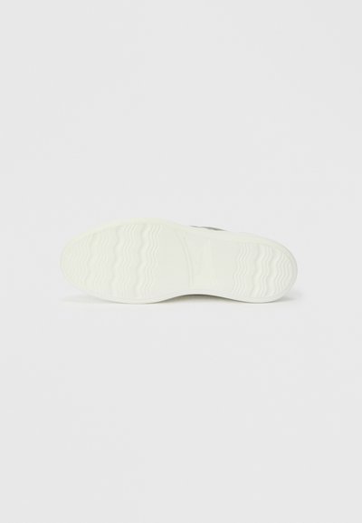 Apavu zole, galvenokārt balta ar teksturētu saķeres rakstu. Gluda apdare ar nelielām viļņainām līnijām un izveidotu logotipa detaļu.