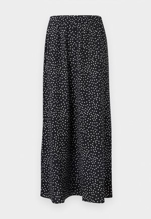 Jupe midi noire à pois blancs irréguliers avec taille élastique, tissu fluide, sans fermetures ni poches visibles.