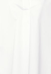 Vit, rynkresistent bomullstyg med en slät yta, vertikala veck och en subtil glans, designat för en klassisk look.