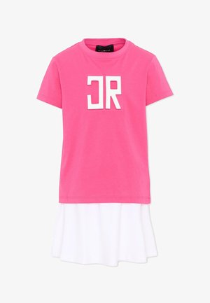 Różowy t-shirt z krótkim rękawem z białymi blokowymi literami „JR” na przodzie, nałożony warstwowo na biały dół spódnicy lub sukienki.