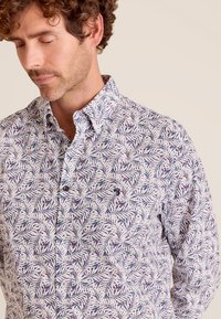 Witte button-up shirt met een kleurrijk bladerenpatroon in blauw en paars. Katoenen stof met klassieke kraag en voorzakdetail.