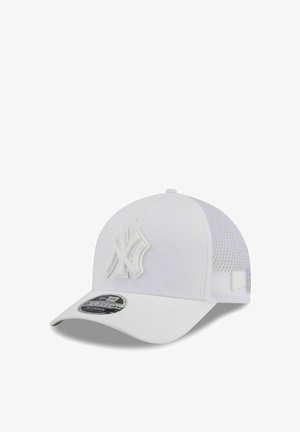Casquette de baseball blanche des New York Yankees avec panneaux arrière en filet et une visière incurvée, affichant le logo à l'avant et un autocollant de la marque sur la visière.