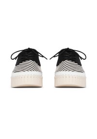 Zapatillas de deporte a rayas blancas y negras con parte superior de tela suave, cierre de cordones y suelas de plataforma blancas con detalles texturales.