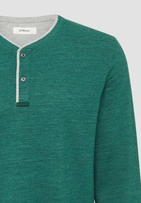 Grünes langärmliges Hemd mit Henley-Ausschnitt, mit einem hellgrauen Kragen, zwei Knöpfen und einem strukturierten Stoff. Markenlabel sichtbar.