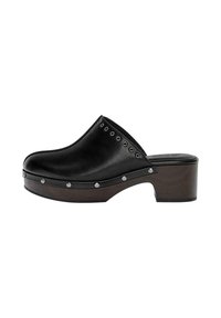 Zwarte leren klomp met een ronde punt, houten plateau en een lage blokhak. Heeft zilveren studs langs de rand voor extra detail.