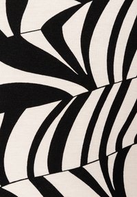 Black and white fabric featuring a bold, abstract leaf pattern with varying shapes and lines on a light beige background.