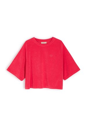 Krótki rękaw, skrócona bluza polarowa w jaskrawo różowym kolorze, wykonana z miękkiej tkaniny frotte, z ribbowanym dekoltem i luźnym krojem.