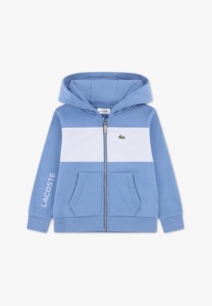 Felpa con cappuccio blu con zip, con una striscia orizzontale bianca, tasche frontali, polsini a costine e un piccolo logo Lacoste verde sul petto.