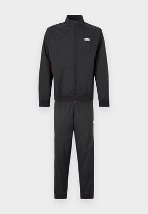 Black tracksuit made of lightweight fabric, featuring a zip-up jacket with ribbed cuffs and pants with elastic ankles. Includes logo detail.