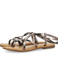 Sandalias planas con tiras de bronce metálico, que presentan múltiples diseños entrelazados, sobre una suela marrón claro con una construcción minimalista.
