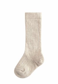 Beige Rippensocke aus einem weichen, strukturierten Stoff. Sie hat eine einfarbige Optik mit einem glatten Bündchen und einer abgerundeten Zehenform.