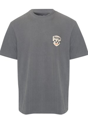 Graues T-Shirt mit kurzen Ärmeln und Rundhalsausschnitt, mit einem kleinen Schild-Logo auf der Brust, darauf der Text "MOTOR" und darüber ein Schachbrettmuster mit der Jahreszahl "2019".