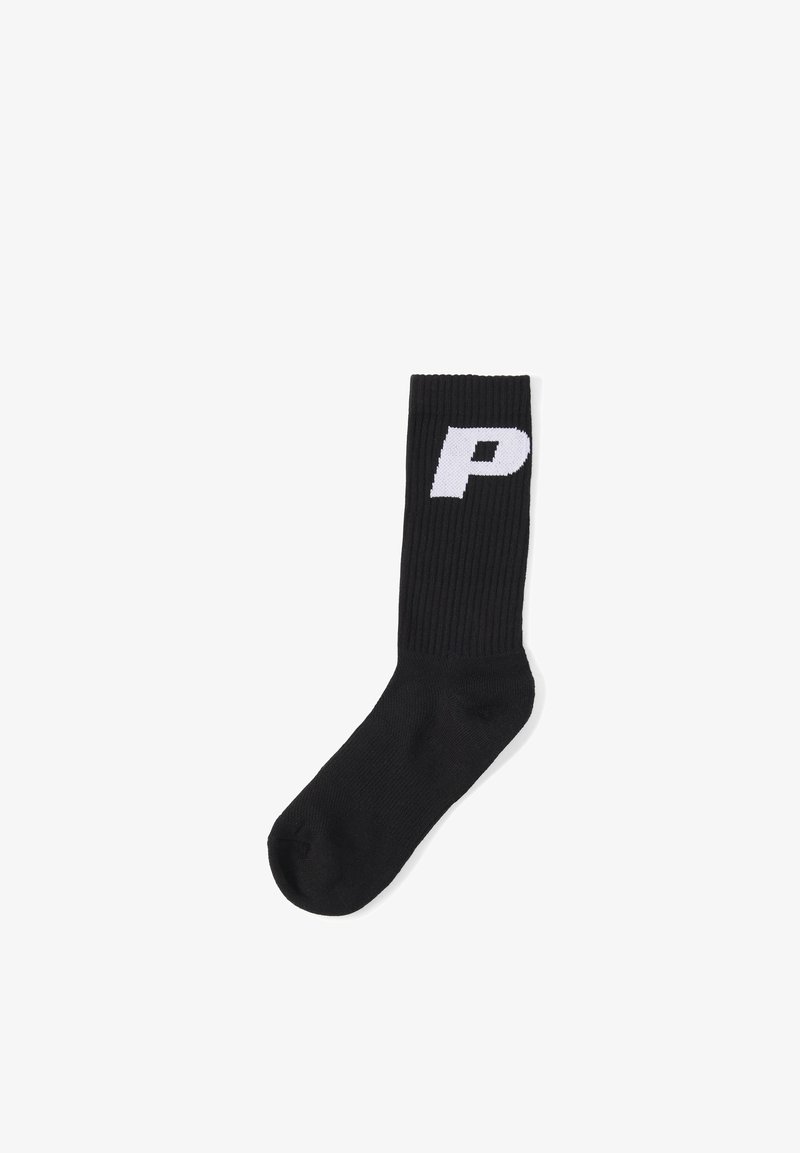 Chaussette noire côtelée avec une grande lettre blanche « P » sur la partie supérieure du mollet, isolée sur fond blanc.