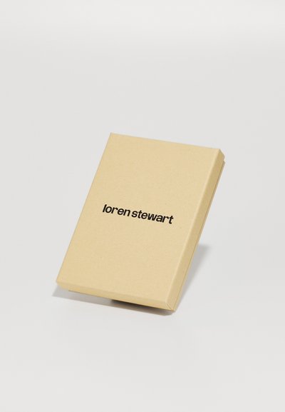 Brūna kartona kaste ar uzliekamu vāku, kurā melnā krāsā ir izdrukāts logo "loren stewart". Vienkāršs, minimālistisks dizains.