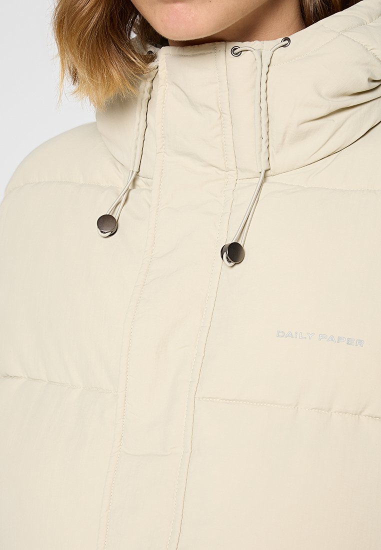 Beige Daunenjacke mit hohem Kragen, frontalem Reißverschluss, verstellbarem Kordelzug-Hood und einem dezenten Markenlogo auf der Brust gestickt.