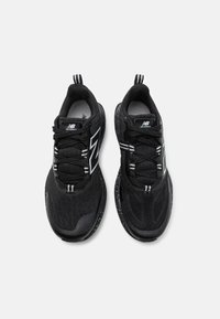 Black mesh sneakers featuring black and white striped accents, round toe, lace-up design, and speckled sole for added texture.