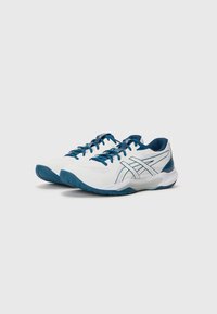 Pantofi sport albi cu accente albastre, parte superioară din plasă texturată și talpă modelată. Dispune de un sistem de șiret și de un logo proeminent pe lateral.
