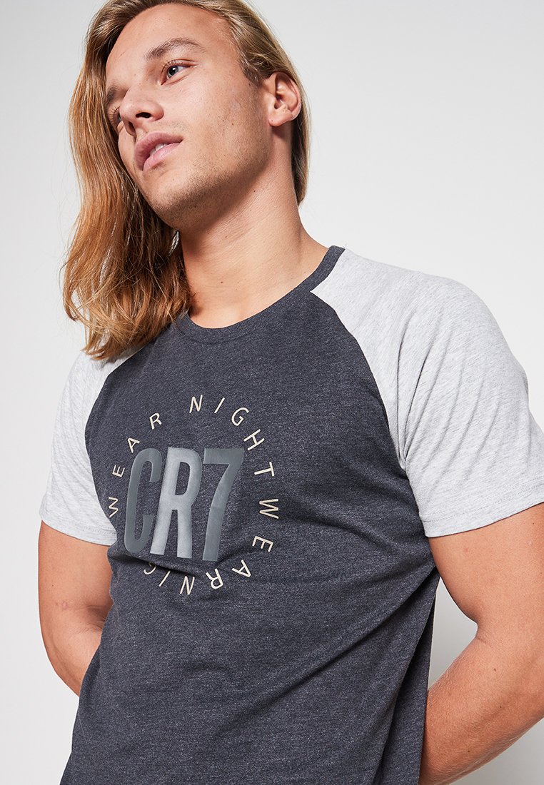Ciemnoszary t-shirt z krótkim rękawem i jasnoszarymi rękawami raglanowymi, z okrągłym logo z napisem "CR7" na środku.