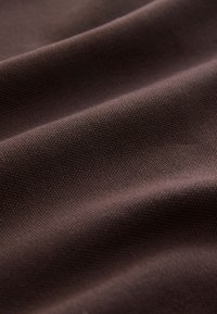 Brun stoftekstur med tæt vævning, der viser en diskret glans og blød fald. Overfladen er glat med lette tonevariationer.