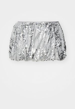 Sukienka z tkaniny srebrnych cekinów z marszczonym wzorem, z różnymi rozmiarami cekinów, które tworzą teksturowaną, odbijającą światło powierzchnię. Elastyczna talia.