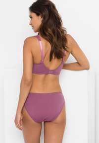 Set di reggiseno e bikini color malva con spalline regolabilli, bordi senza cuciture e una texture morbida e liscia. La chiusura sul retro è discreta e semplice.