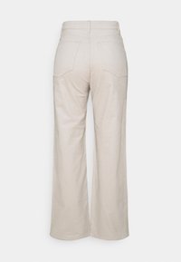 Pantalon large en velours côtelé beige clair à taille haute, avec deux poches arrière et une texture côtelée subtile.