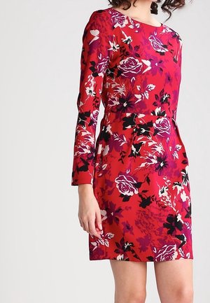 Rotes Blumenkleid mit langen Ärmeln, das eine Vielzahl von Rosenmustern in Schwarz, Lila und Weiß vor einem lebhaften Hintergrund zeigt.