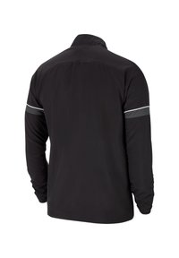 Chaqueta negra de manga larga con cuello alto, con acentos reflectantes en las mangas. Textura suave y material ligero.
