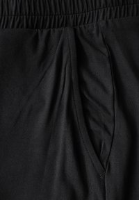 Zwarte katoenen joggers met een elastische tailleband, subtiele textuur en een zijzak met een nette stikselafwerking.