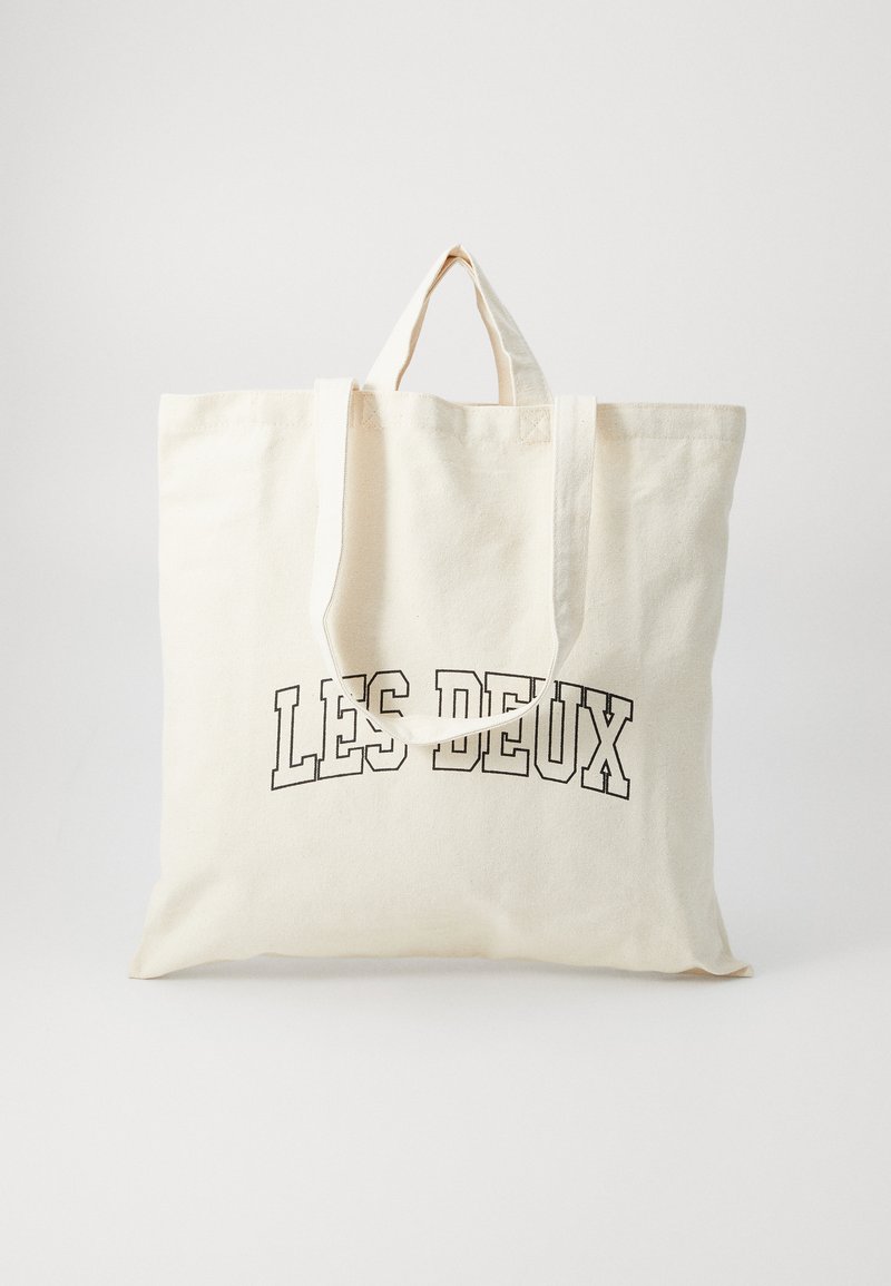 Canvas shopperbag i off-white, med korte håndtak og teksten "LES DEUX" trykt i fet sorte bokstaver. Holdbart, enkelt design.