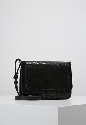 Zwarte crossbodytas met een getextureerd slangenhuidpatroon, verstelbare band en klepsluiting, getoond op een wit oppervlak tegen een grijze achtergrond.