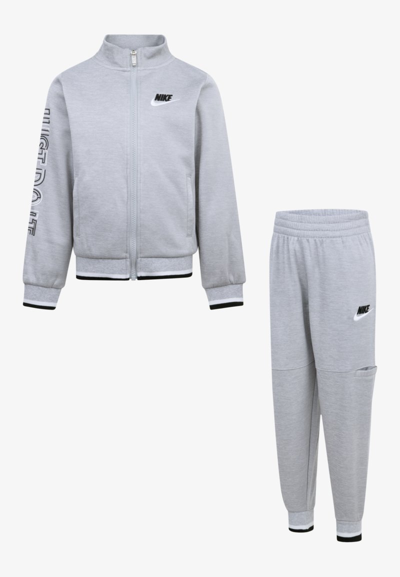 Trening Nike gri, compus dintr-o jachetă cu fermoar, inscripționată cu textul "JUST DO IT", și pantaloni asortați, tapered, cu talie elastică și buzunar lateral.