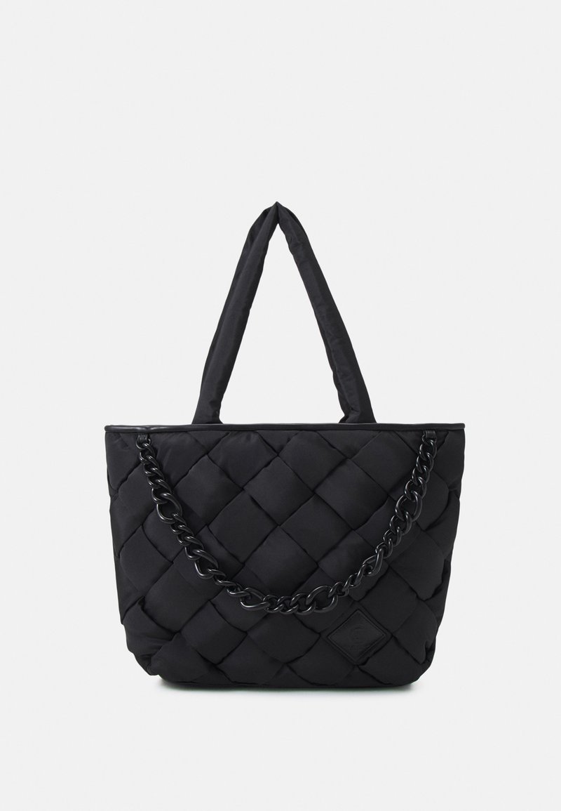 Sac cabas noir matelassé avec poignées rembourrées et une bandoulière chaîne noire décorative sur le devant, sur fond uni.
