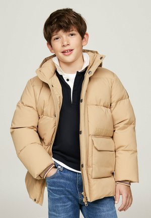 Beige gewatteerde jas met een capuchon, geribbelde manchetten en een sluiting met knopen aan de voorkant. Beschikt over een zichtbaar logo en een ritszak aan de linkerkant.