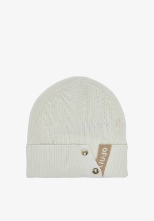 Hvid strikket hue med foldet kant, to guldfarvede knapper og et beige mærke med delvis hvid tekst i højre side.