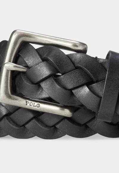 Czarny pleciony skórzany pasek z srebrną metalową klamrą z wygrawerowanym słowem "POLO" na jednolitym tle.