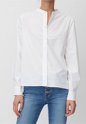 Witte overhemd met knopen van glad katoen. Voorzien van een opstaande kraag, lange mouwen en een rechte snit. Gecombineerd met spijkerbroek.