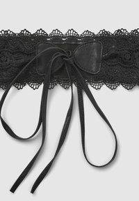 Cintura in pizzo nero con una larga fascia di pizzo, dotata di una fascia in pelle liscia al centro e lunghi lacci in pelle per la chiusura.