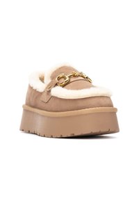 Mule in suede beige con rifinitura in pelo sintetico. Presenta un dettaglio in metallo dorato e una suola in gomma texturizzata per una migliore presa.