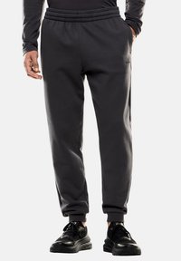 Pantaloni jogger grigio scuro con vita elastica, tasche laterali e design a gamba affusolata, realizzati in un morbido tessuto testurizzato.