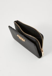 Portafoglio nero con zip realizzato in materiale testurizzato, caratterizzato da un dettaglio del logo in tonalità oro sulla parte anteriore e una fodera interna liscia.