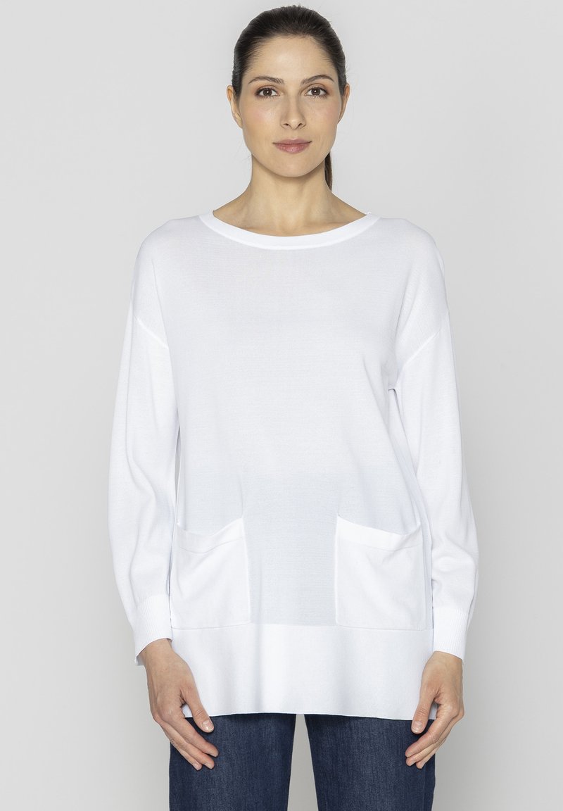 Biała dzianinowa bluzka z długim rękawem i okrągłym dekoltem, z dwoma kieszeniami z przodu i prostym dołem. Miękka tekstura, luźny krój.