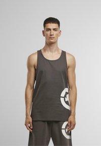 Gray tank top made of cotton blend, featuring a round neckline and a large white printed graphic on the bottom right. Simple, lightweight design.