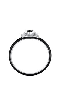 Anillo negro con acabado liso que presenta una piedra negra central, flanqueada por tres piedras claras más pequeñas, engastadas en acentos metálicos de tono plateado.