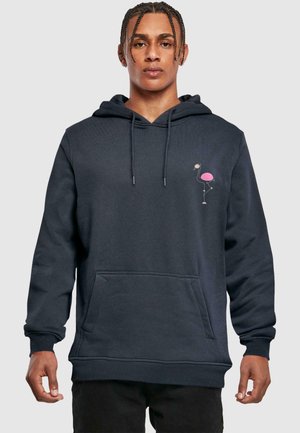 Tumedast hallist kapuutsiga särk, mis on valmistatud pehmest materjalist. Vasakul rinnal on roosa flamingo graafika, kangaroopocket ja reguleeritav kapuuts.