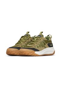 Un paio di sneaker verde oliva con suole beige, punte nere, texture in rete e suede, e branding "VOILE" sui pannelli laterali.