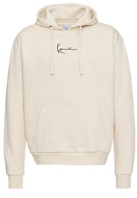Creme hoodie lavet af blødt materiale. Har en kengurulomme, ribbede manchetter og et subtilt sort logo på brystet. Afslappet design.