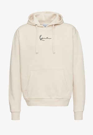 Kremowa bluza z kapturem wykonana z miękkiego materiału. Posiada kieszeń kangurkę, ściągacze na rękawach oraz subtelne czarne logo na piersi. Styl casualowy.